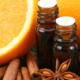 Aromatherapy essential oil bottles, star anise, cinnamon sticks, oranges, nutmeg