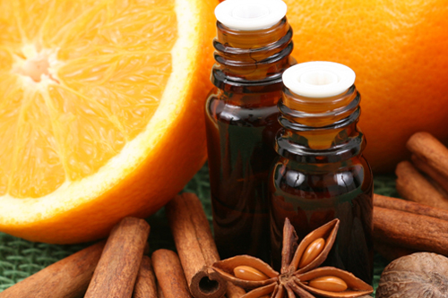 Aromatherapy essential oil bottles, star anise, cinnamon sticks, oranges, nutmeg
